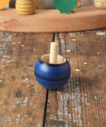 Mader Luna turn over spinning top shown on a wooden desk in the Babipur playroom.