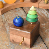 Mader Kreiselmanufaktur luna music box in the Babipur playroom. Wind up musical box with two slots, green tree shaped spinner and luna moon and starts design turn over spinning top.