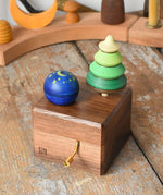 Mader Kreiselmanufaktur luna music box in the Babipur playroom. Wind up musical box with two slots, green tree shaped spinner and luna moon and starts design turn over spinning top.