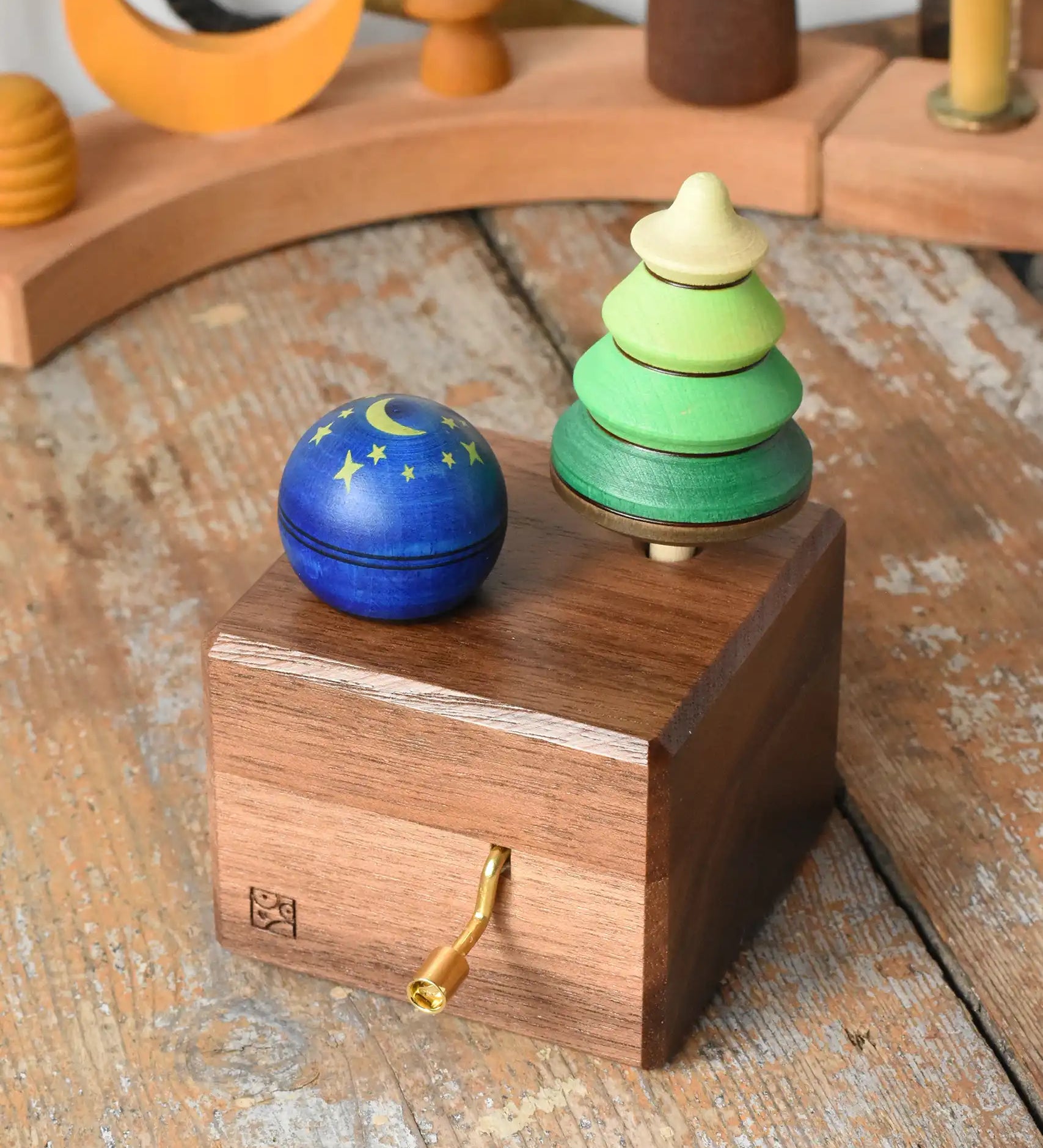 Mader Kreiselmanufaktur luna music box in the Babipur playroom. Wind up musical box with two slots, green tree shaped spinner and luna moon and starts design turn over spinning top.