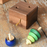 Mader Kreiselmanufaktur luna music box in the Babipur playroom. Wind up musical box with two slots, green tree shaped spinner and luna moon and starts design turn over spinning top.