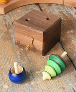 Mader Kreiselmanufaktur luna music box in the Babipur playroom. Wind up musical box with two slots, green tree shaped spinner and luna moon and starts design turn over spinning top.