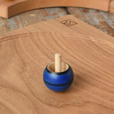 Mader Luna turn over spinning top shown on an oak spinning plate in the Babipur playroom.