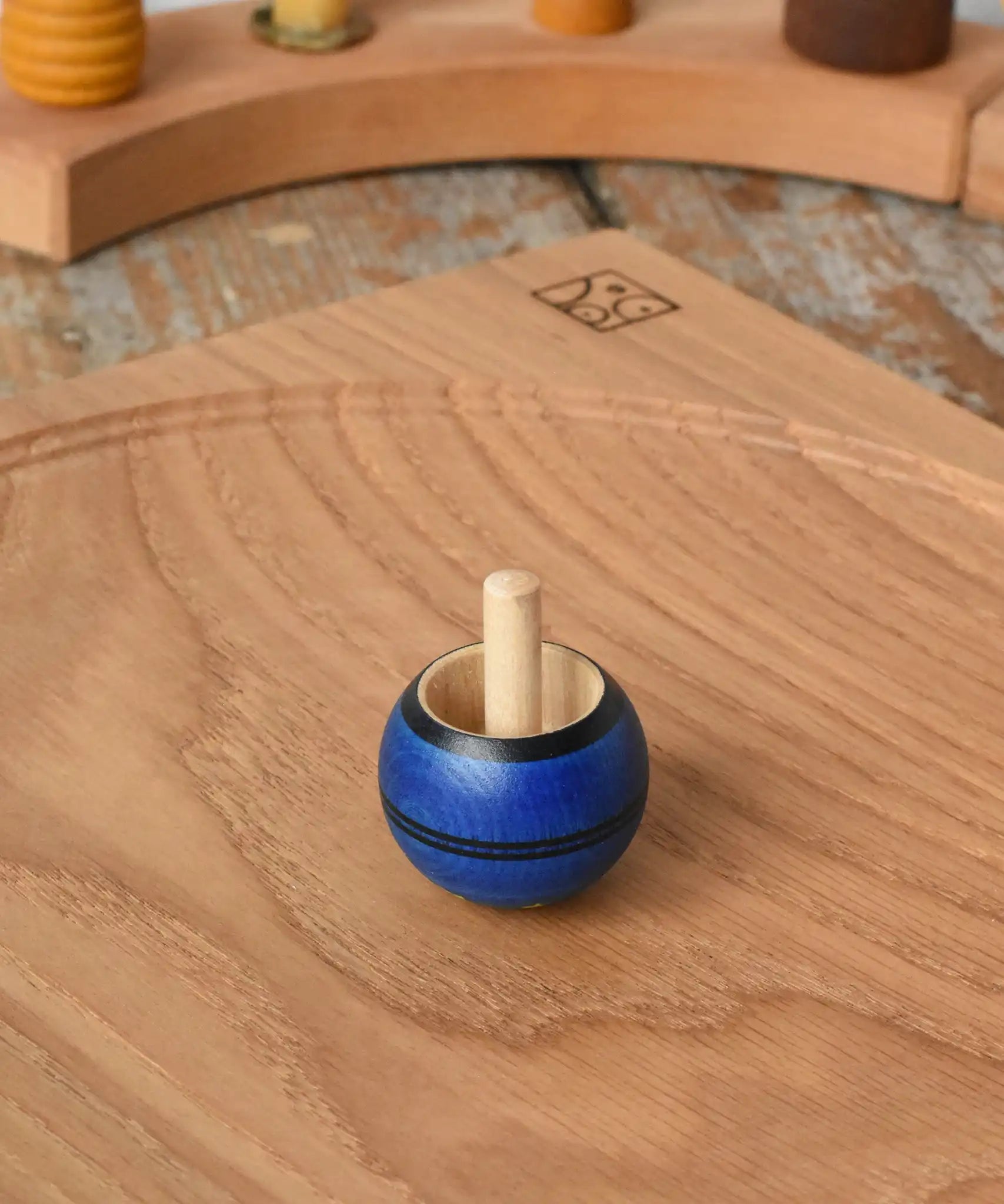 Mader Luna turn over spinning top shown on an oak spinning plate in the Babipur playroom.