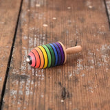 Mader handcrafted wooden rainbow mini thunderbolt spinning top placed on a wooden surface in the Babipur playroom. 