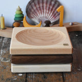 Mader ash, walnut and maple medium wooden spinning plates 15cm stacked on a wooden surface in the Babipur playroom.