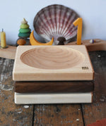 Mader ash, walnut and maple medium wooden spinning plates 15cm stacked on a wooden surface in the Babipur playroom.