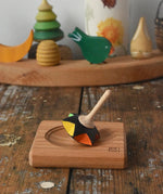 Mader Kreiselmanufaktur superstar wooden spinning top toy with and spinning plate placed on a wooden desk in the Babipur playroom.