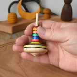 Mader Monalotte Spinning Top in an adult's hand in the Babipur playroom.
