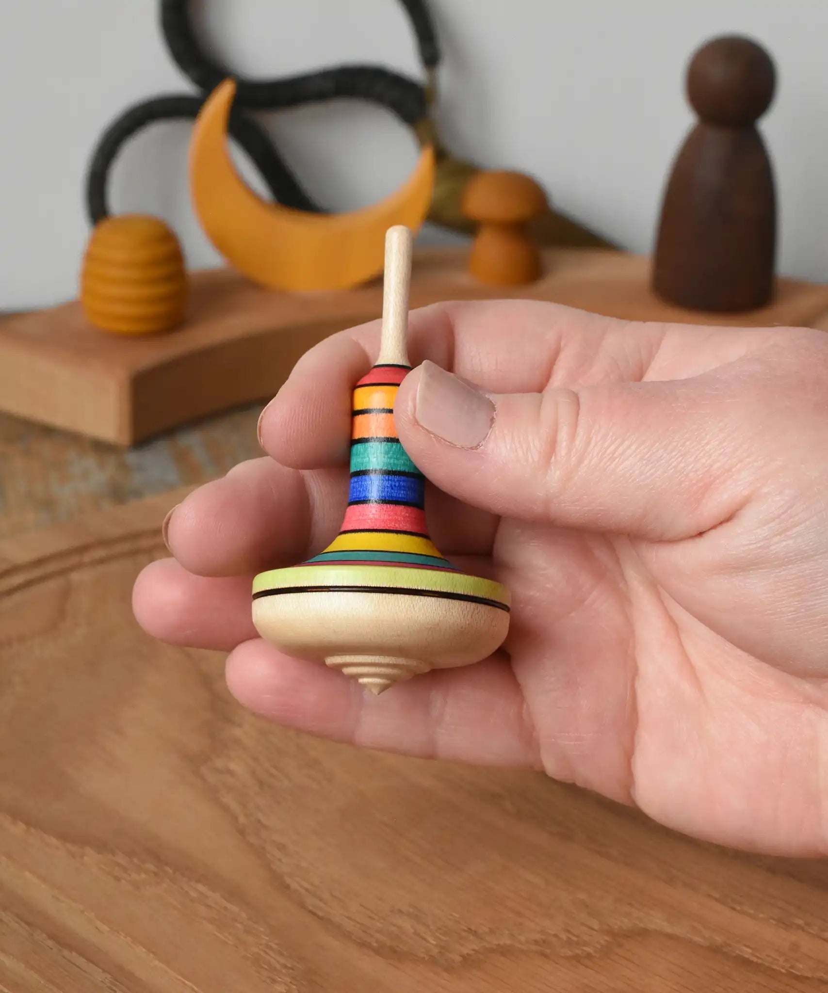 Mader Monalotte Spinning Top in an adult's hand in the Babipur playroom.