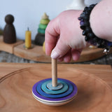 Mader my first spinning top toy in purple placed on a large cherry wood  spinning plate in the Babipur playroom. 