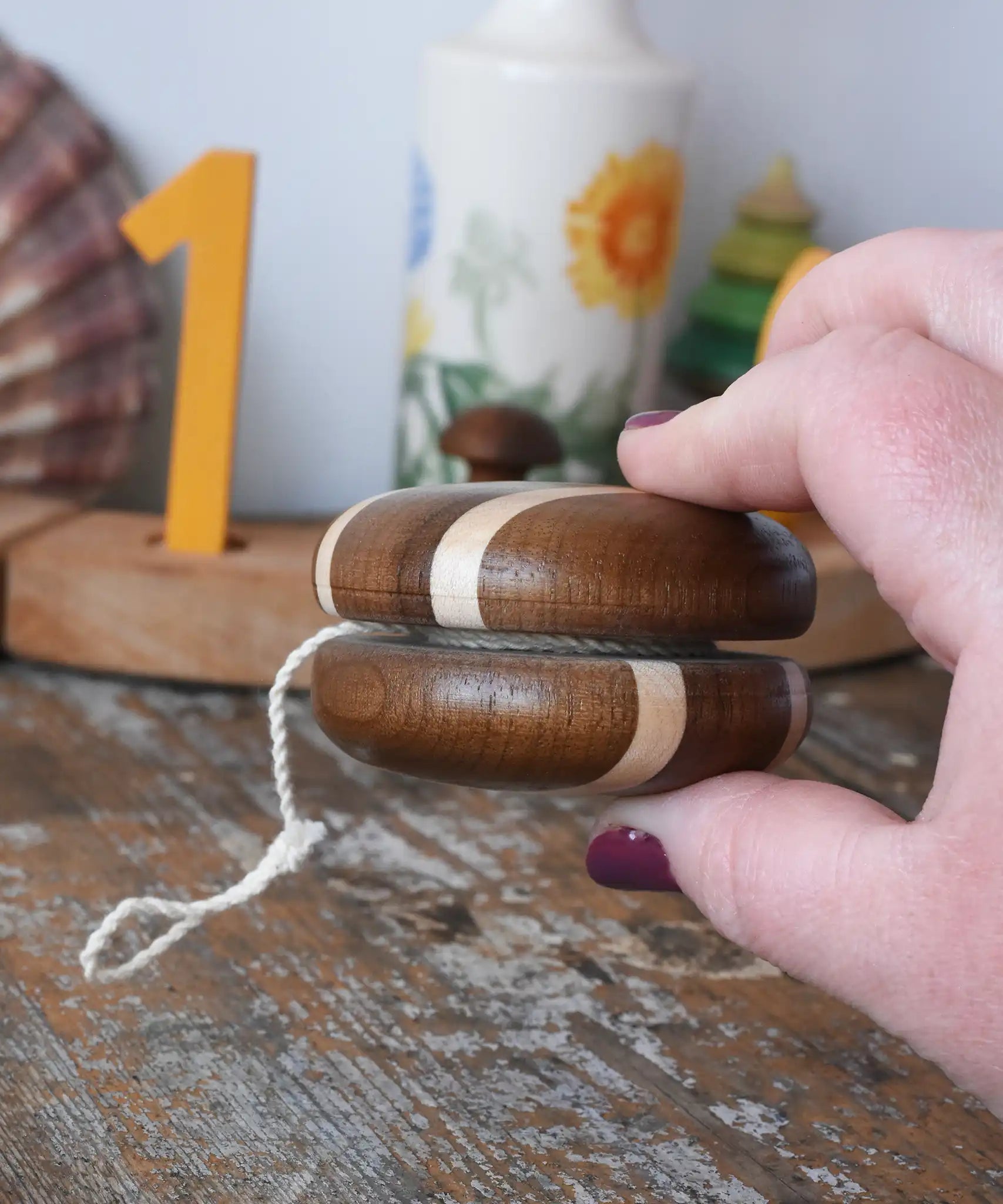 Side view of the Mader natural freewheel yoyo in an adult hand.