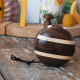 Mader natural yoyo placed on a wooden surface in the Babipur playroom. Decorated Grimm's celebration ring in the background. 