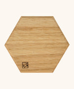 underside of the Mader handcrafted small oak spinning top plate in a shape of a hexagon showing the logo on the corner