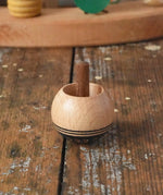 Mader orient turn-over spinning top placed on a wooden desk in the Babipur playroom.
