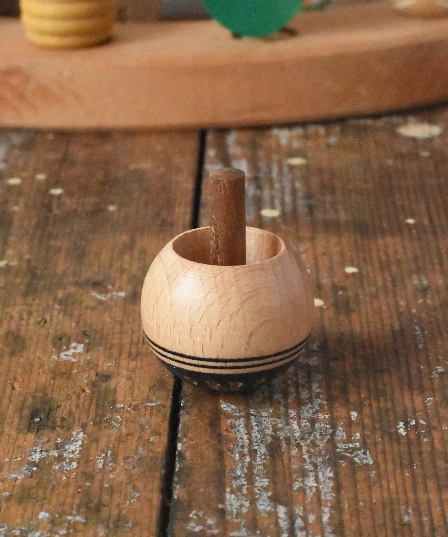 Mader orient turn-over spinning top placed on a wooden desk in the Babipur playroom.
