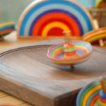 Mader striped sombrero spinning top twirling around on a mader spinning plate in front of a lanka kade x babipur sunset