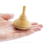 Close up of a Mader handmade classic wooden spinning top toy in the palm of a hand