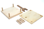 Pieces of the Mader plastic-free carved wooden flower press kit laid out on a white background