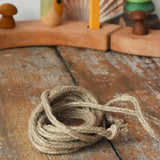 The rope from the Mader natural profi throw spinning top placed on a wooden surface in the Babipur playroom.  