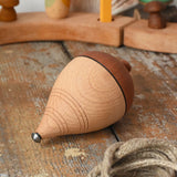 Mader natural profi throw spinning top with the string taken off the wooden body placed on a wooden surface in the Babipur playroom. 