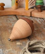 Mader natural profi throw spinning top with the string taken off the wooden body placed on a wooden surface in the Babipur playroom. 