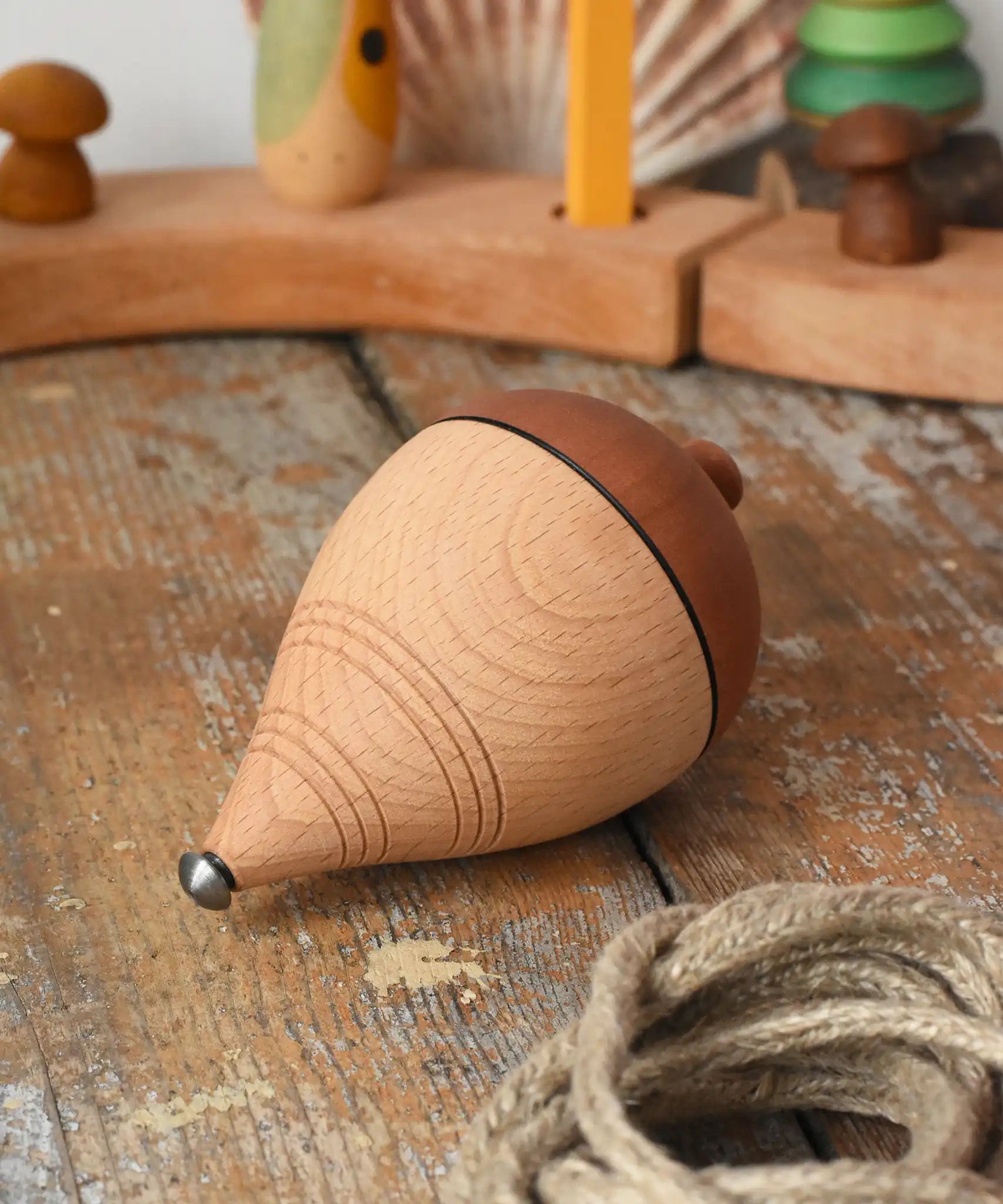 Mader natural profi throw spinning top with the string taken off the wooden body placed on a wooden surface in the Babipur playroom. 