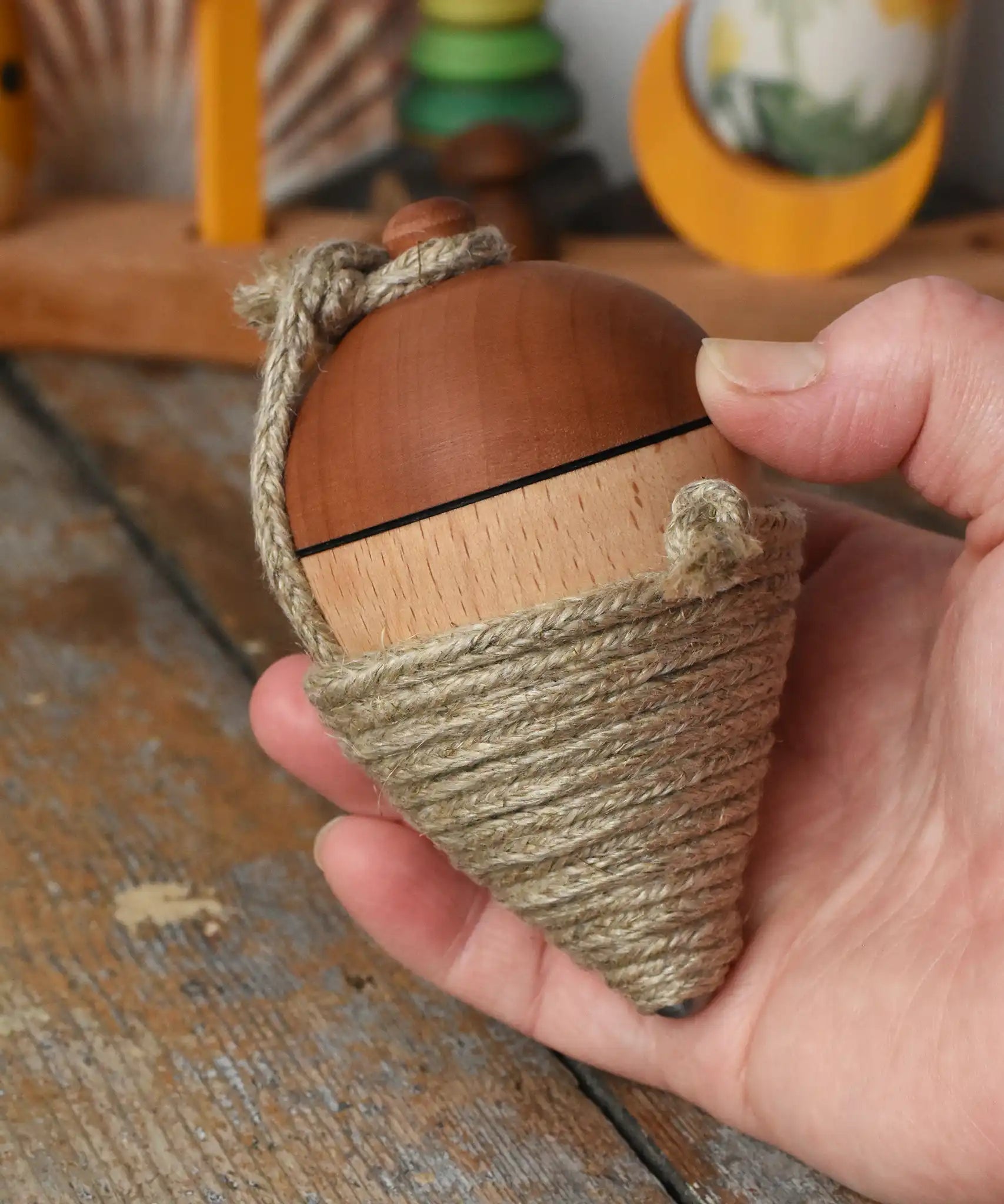 Mader natural profi throw spinning top in an adult hand.