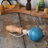 Mader blue pull-string spinning top spinning placed on a wooden surface in the Babipur playroom.