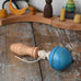 Mader blue pull-string spinning top spinning placed on a wooden surface in the Babipur playroom.