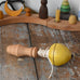Mader yellow pull-string spinning top spinning placed on a wooden surface in the Babipur playroom.