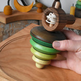 Mader pull-string tree spinning top placed on a cherry wood spinning plate in the Babipur playroom.