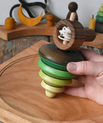Mader pull-string tree spinning top placed on a cherry wood spinning plate in the Babipur playroom.