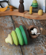 Mader pull-string tree spinning top placed on a wooden surface in the Babipur playroom.