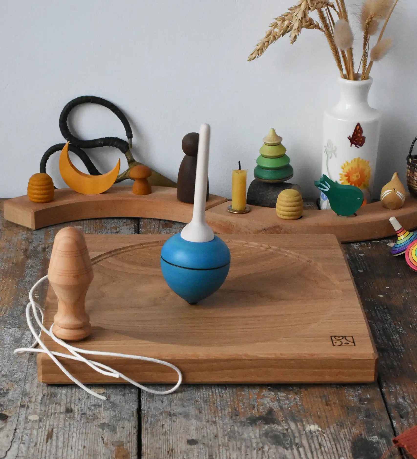 Mader blue pull-string spinning top spinning on a large oak spinning plate in the Babipur playroom.