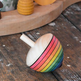 Mader Kreiselmanufaktur rainbow egg spinning top placed on a wooden surface in the Babipur playroom.