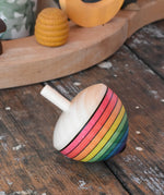 Mader Kreiselmanufaktur rainbow egg spinning top placed on a wooden surface in the Babipur playroom.