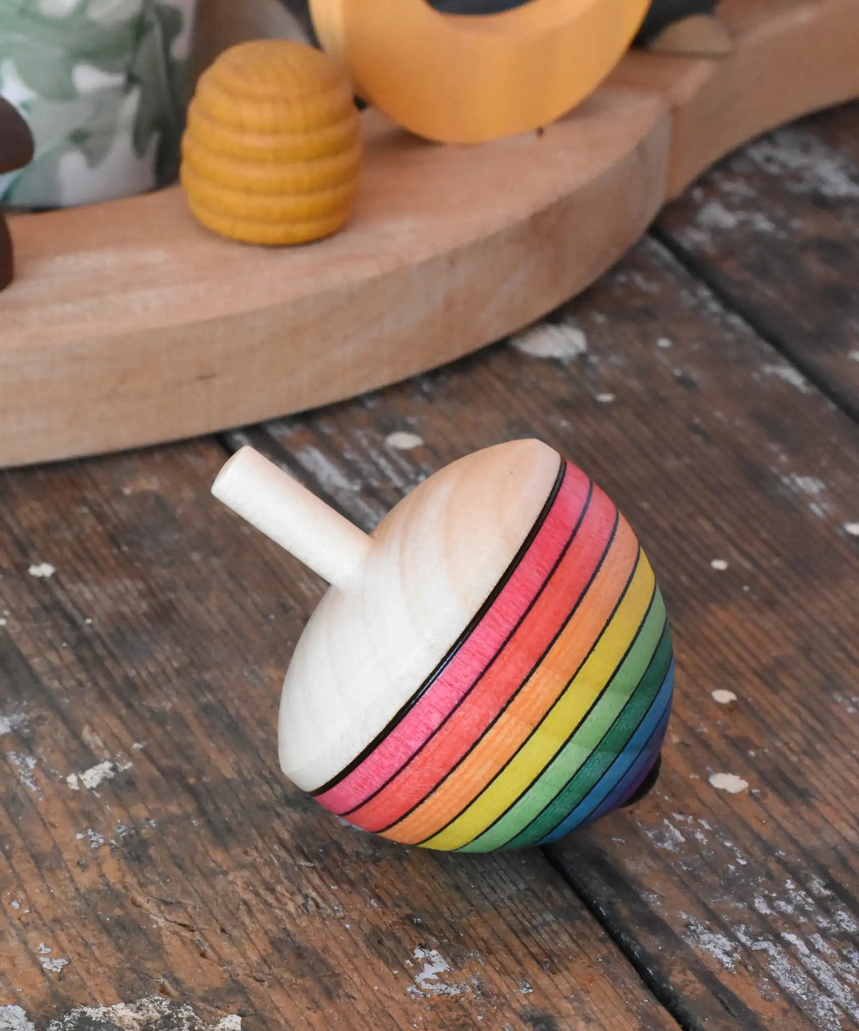 Mader Kreiselmanufaktur rainbow egg spinning top placed on a wooden surface in the Babipur playroom.