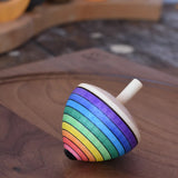 Mader Kreiselmanufaktur rainbow egg spinning top placed on a walnut spinning plate in the Babipur playroom.