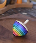 Mader Kreiselmanufaktur rainbow egg spinning top placed on a walnut spinning plate in the Babipur playroom.