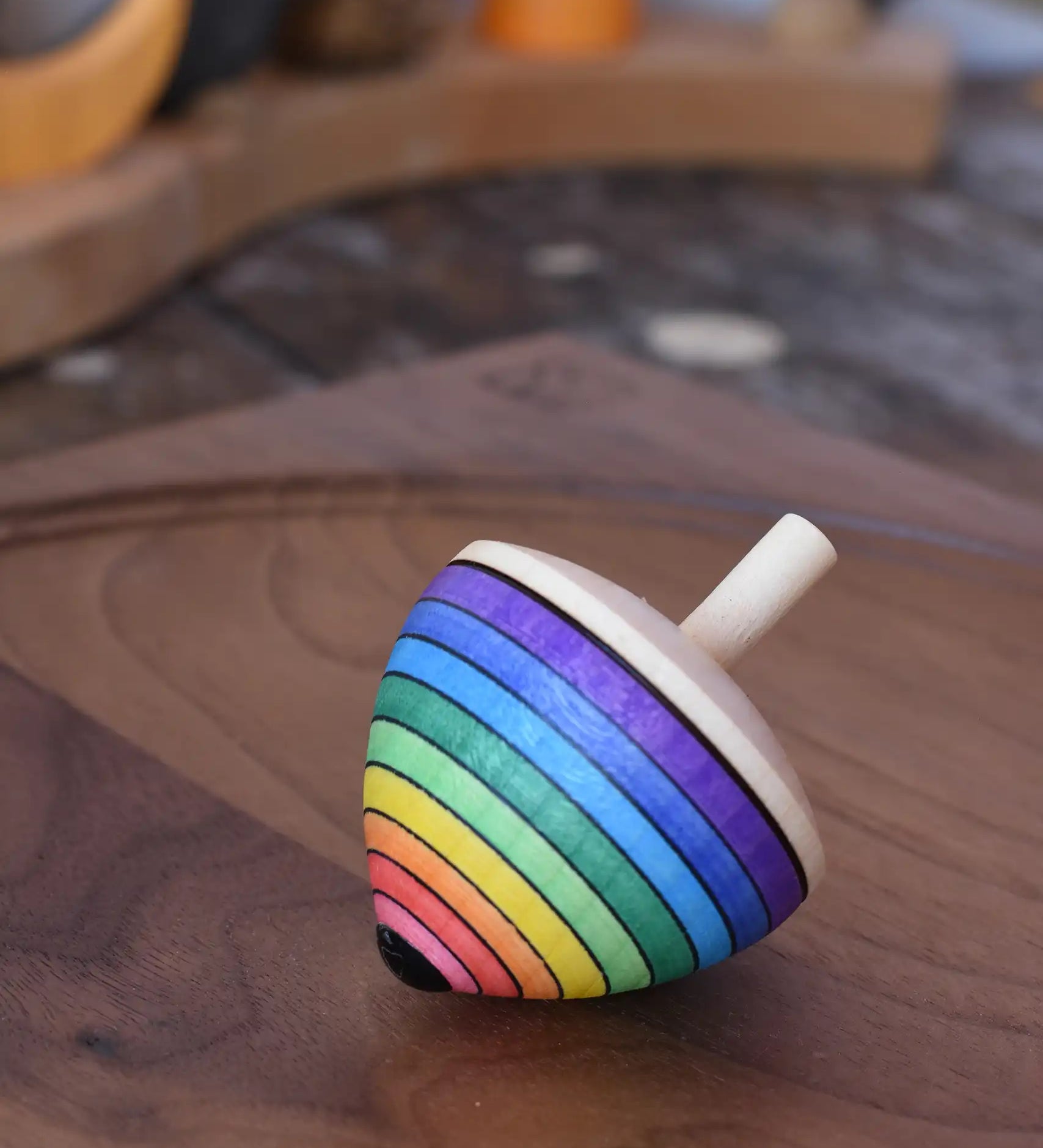 Mader Kreiselmanufaktur rainbow egg spinning top placed on a walnut spinning plate in the Babipur playroom.
