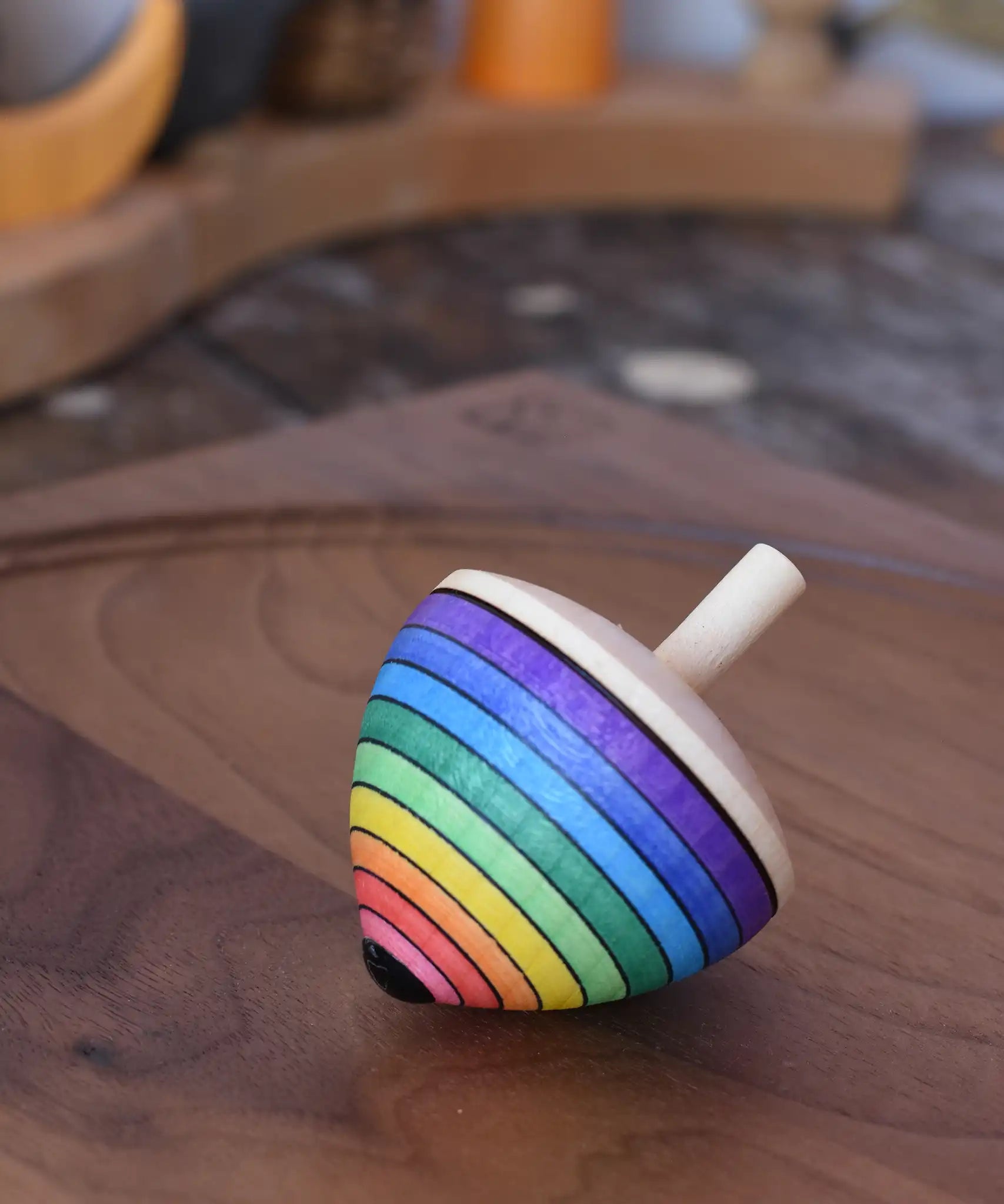 Mader Kreiselmanufaktur rainbow egg spinning top placed on a walnut spinning plate in the Babipur playroom.