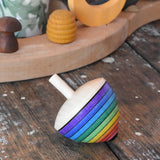 Mader Kreiselmanufaktur rainbow egg spinning top placed on a wooden surface in the Babipur playroom.