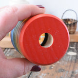 Mader Rainbow Kaleidoscope placed in an adult's hand with the viewing peep hole facing the camera. 