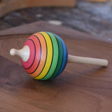 Mader Kreiselmanufaktur rainbow lolly spinning top placed on a walnut spinning plate in the Babipur playroom.