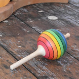 Mader Kreiselmanufaktur rainbow lolly spinning top placed on a wooden surface in the Babipur playroom.