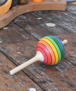 Mader Kreiselmanufaktur rainbow lolly spinning top placed on a wooden surface in the Babipur playroom.