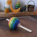 Mader Kreiselmanufaktur rainbow lolly spinning top placed on a walnut spinning plate in the Babipur playroom.