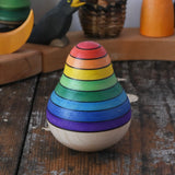 Mader wooden rainbow roly-poly wobbly pear toy placed on a wooden surface in the Babipur playroom.