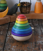 Mader wooden rainbow roly-poly wobbly pear toy placed on a wooden surface in the Babipur playroom.